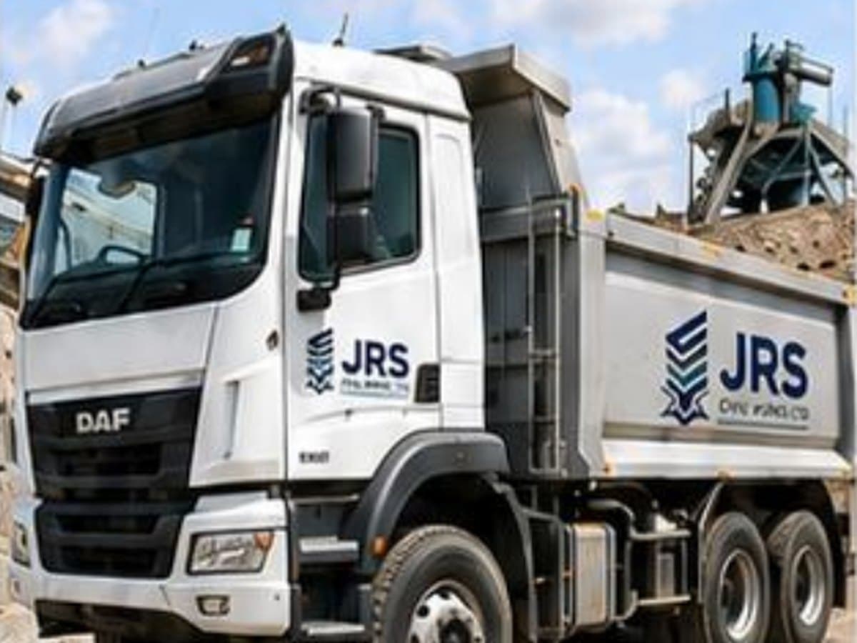 A JRS-branded six-wheel dump truck loaded with material on a construction site.