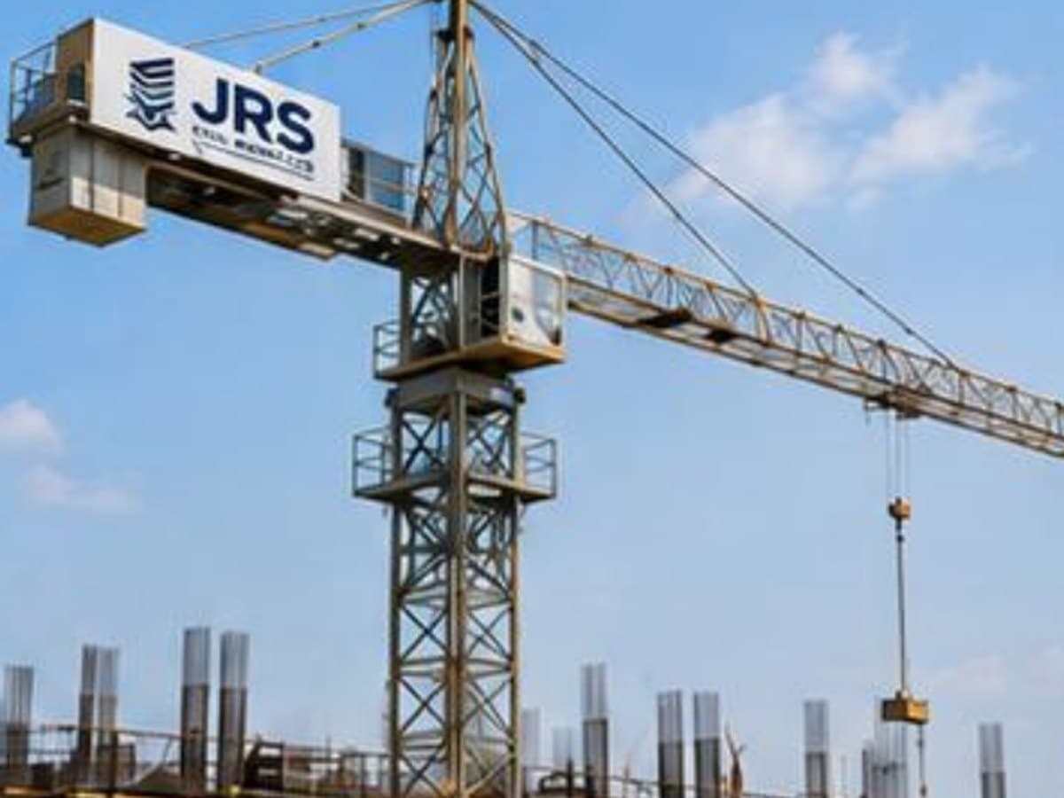 A JRS-branded tower crane standing over a reinforced concrete building under construction.